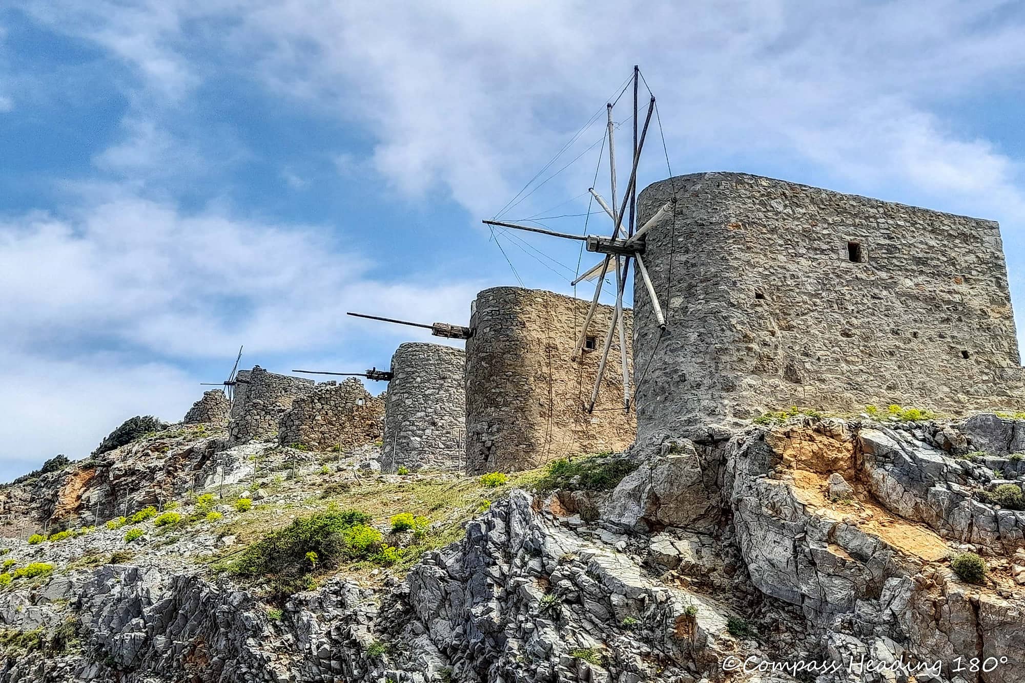 Grey stone windmills on a rugged mountain.