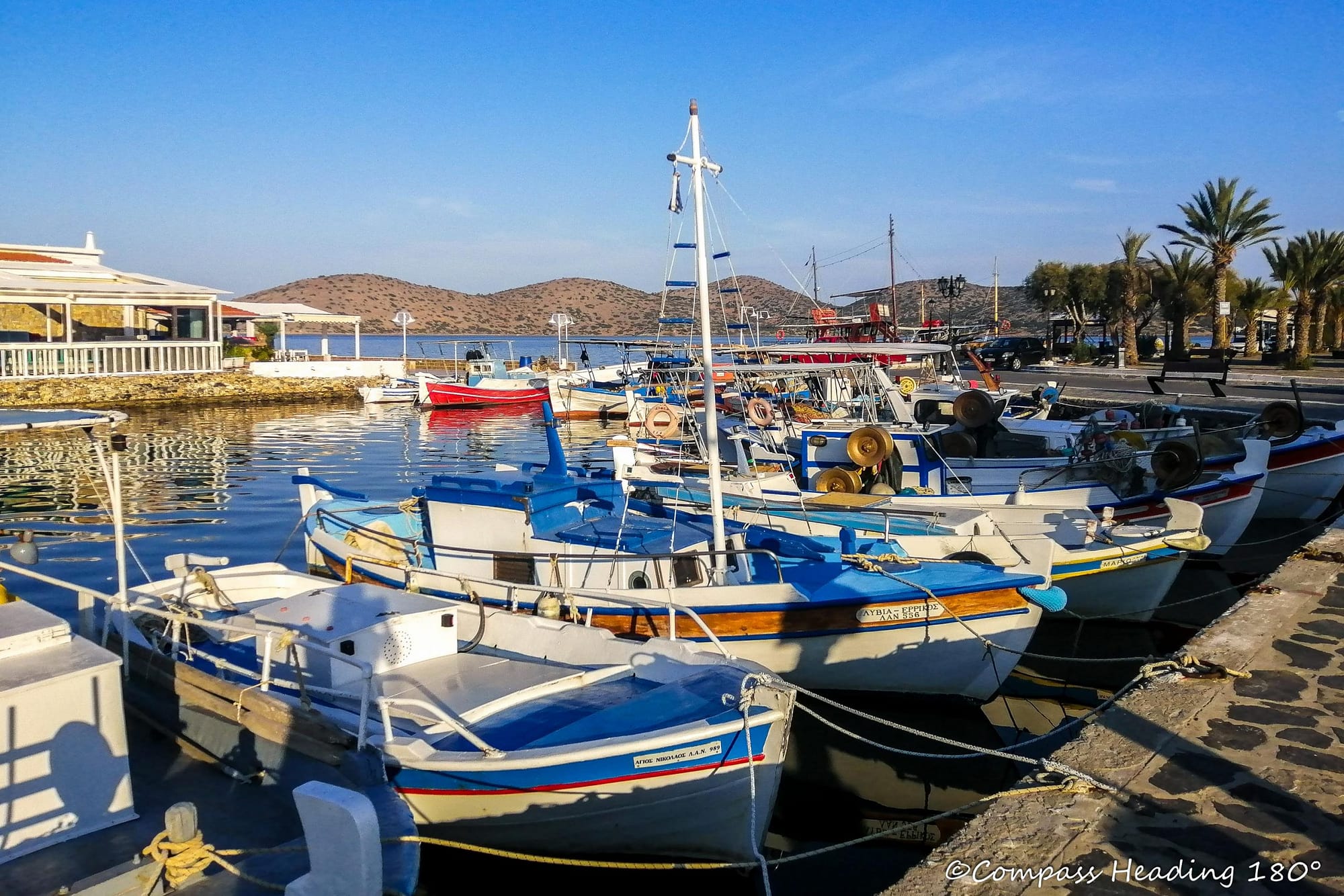 Elounda fishing harbour is full of colourful boats.