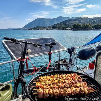 Delicious barbeque food roasting on the aft deck, with the mountains and the blue sea as background